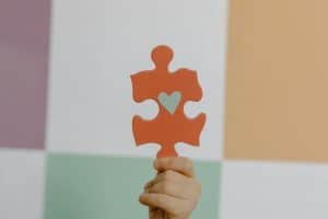 Person Holding Orange Puzzle Piece