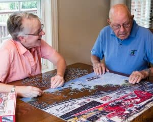 adults solving jigsaw puzzle