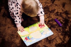 toddler's solving jigsaw puzzle on floor