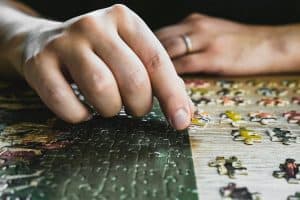 a close up of a person's hand on a jigsaw puzzle