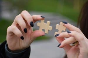 a person holding a pair of jigsaw pieces