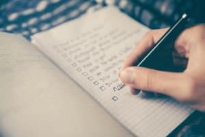 person writing plan on book